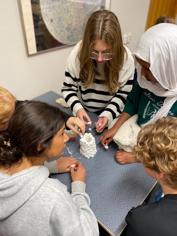 fyra elever som bygger en pyramid av sockerbitar.